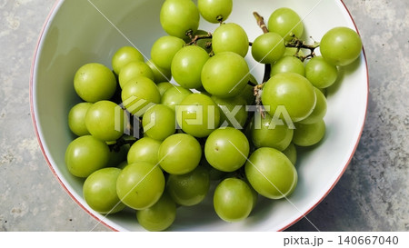 Fresh green Shine Muscat grapes bunch in a white bowl Fresh green Shine Muscat grapes bunch in a white bowl 140667040