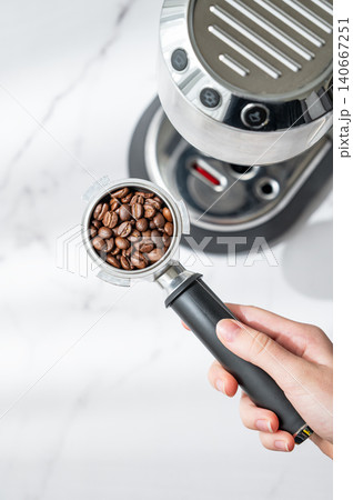 Preparing espresso with portafilter and home coffee machine in natural sunlight Preparing espresso with portafilter and home coffee machine in natural sunlight 140667251