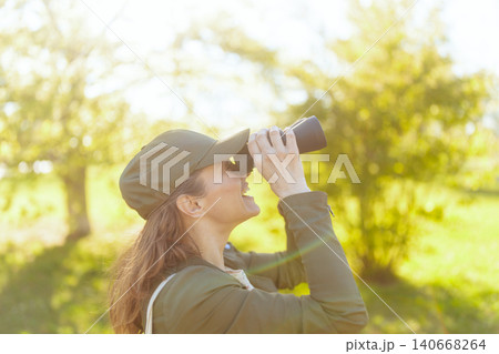 Smiling Woman Enjoying Bird Watching Adventure 140668264