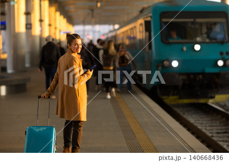 Woman with Suitcase Smiling at Train Station Woman with Suitcase Smiling at Train Station 140668436