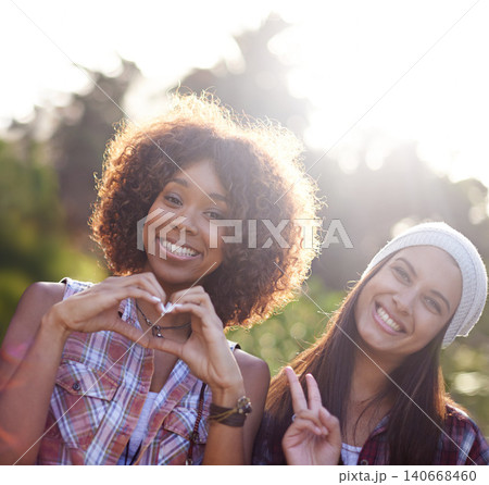Portrait, friends and smile with emoji for peace sign, heart hands and weekend trip outdoors. Happiness, lens flare and face of diverse people in sunshine for bonding, travel and hand gesture Portrait, friends and smile with emoji for peace sign, heart hands and weekend trip outdoors. Happiness, lens flare and face of diverse people in sunshine for bonding, travel and hand gesture 140668460