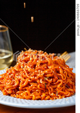 Spicy instant noodles with hot chili sauce, sprinkled with sesame seeds on a plate. Spicy instant noodles with hot chili sauce, sprinkled with sesame seeds on a plate. 140668709