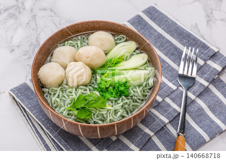 Healthy green spinach noodles with white fish balls and bok choy cabbage in a ceramic bowl 140668718