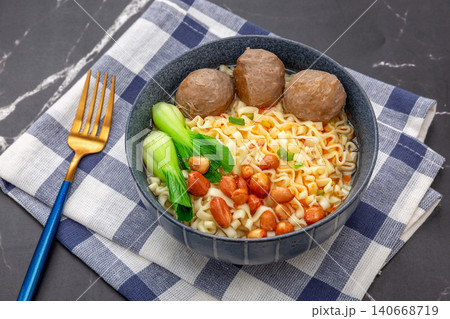 Instant egg noodles served with savory beef meatballs, roasted peanuts, and green vegetables Instant egg noodles served with savory beef meatballs, roasted peanuts, and green vegetables 140668719