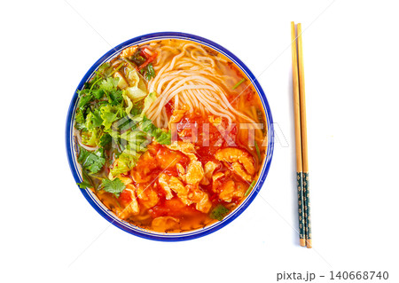 Classic Chinese tomato and egg noodle soup garnished with fresh green vegetables in a blue ceramic bowl Classic Chinese tomato and egg noodle soup garnished with fresh green vegetables in a blue ceramic bowl 140668740