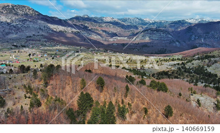 Mountain peak and small village in green valley 140669159