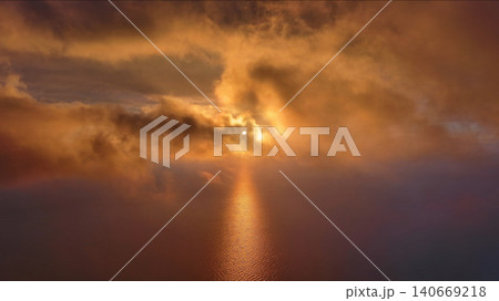 Moving in clouds to bright sun setting over calm sea Moving in clouds to bright sun setting over calm sea 140669218