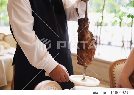 Waiter, fine dining and meat with service, skewer and restaurant for dinner or lunch. Person, food and luxury with gourmet, meal and expensive cuisine with beef or protein on stake at elegant diner Waiter, fine dining and meat with service, skewer and restaurant for dinner or lunch. Person, food and luxury with gourmet, meal and expensive cuisine with beef or protein on stake at elegant diner 140669299