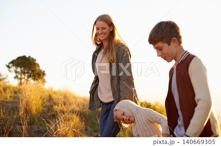 Happy, mother and children on nature walk, family or fun for health in morning. Exercise and child in countryside with kids holding hands, smile in field on vacation or holiday with people together 140669305