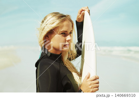 Surfer, face and surfboard for surfing in beach, Cape Town and training for sports in nature. Athlete, outdoor and adventure in sea, free and swimsuit for waves in summer, water and natural in sun 140669310