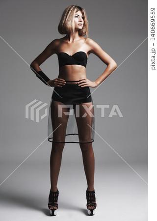 Studio, confident and woman with underwear, fashion and platform heels for trend in dark background. Serious, female person and girl with glamour, stylish and clothes for aesthetic and model 140669589