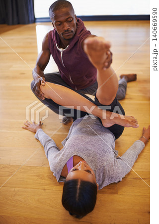 Dancer, coach and stretching with help for legs in class for warm up, fitness or muscle on floor. Man, woman and support for dancing, workout or ready to start with creativity in studio for exercise 140669590