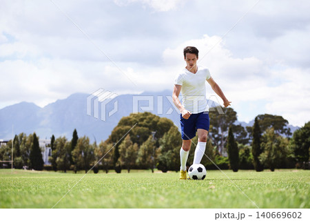 Man, soccer player and dribble with ball on field for moving, speed or skills in low angle at club on training ground. Person, football and sport with exercise, steps and workout for fitness in game Man, soccer player and dribble with ball on field for moving, speed or skills in low angle at club on training ground. Person, football and sport with exercise, steps and workout for fitness in game 140669602