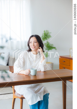 リビングでコーヒーを飲む若い女性 リビングでコーヒーを飲む若い女性 140669886