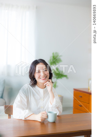 リビングでコーヒーを飲む若い女性 リビングでコーヒーを飲む若い女性 140669893
