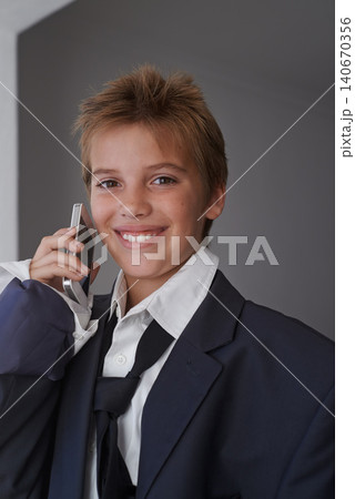 Portrait, child and pretend suit on boy, smartphone or business call for dream job or dress up on kid. Smile, happy in clothes on career day for school, talk on communication technology with costume Portrait, child and pretend suit on boy, smartphone or business call for dream job or dress up on kid. Smile, happy in clothes on career day for school, talk on communication technology with costume 140670356