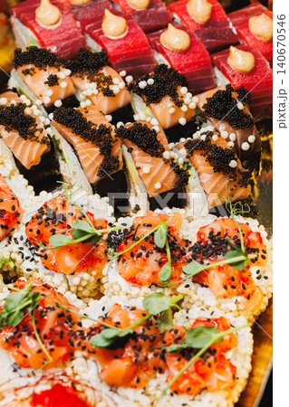 Sushi platter with assorted types of sushi served on a large tray at a gathering in a restaurant Sushi platter with assorted types of sushi served on a large tray at a gathering in a restaurant 140670546