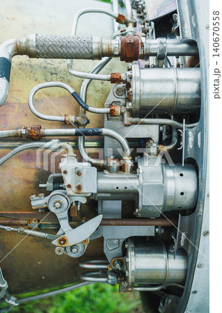 Close view of metal machinery components showing pipes and valves in an industrial setting during daytime Close view of metal machinery components showing pipes and valves in an industrial setting during daytime 140670558