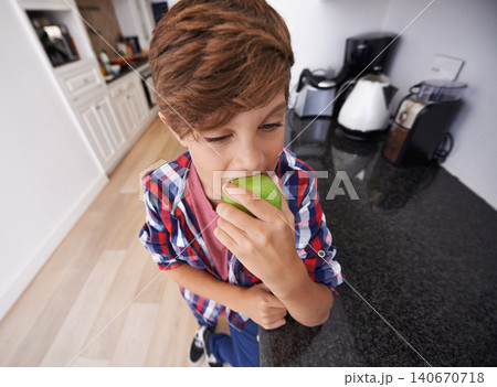 Face, kitchen and boy biting apple in home as diet, health or nutrition for child development closeup. Food, kids and snack with young teen eating green fruit in apartment for hunger or growth Face, kitchen and boy biting apple in home as diet, health or nutrition for child development closeup. Food, kids and snack with young teen eating green fruit in apartment for hunger or growth 140670718