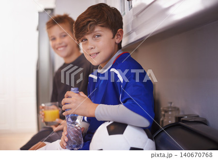 Children, portrait and soccer ball as friends in home with drink for sports training in kitchen for exercise, workout or juice. Male people, athlete and face in apartment with water, cardio or kit Children, portrait and soccer ball as friends in home with drink for sports training in kitchen for exercise, workout or juice. Male people, athlete and face in apartment with water, cardio or kit 140670768