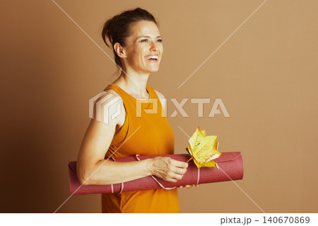 Fall Wellness: Woman with Yoga Mat and Leaf Fall Wellness: Woman with Yoga Mat and Leaf 140670869