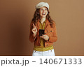 Inspired Woman Pointing Up with Smartphone Inspired Woman Pointing Up with Smartphone 140671333