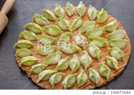 handmade Green Vegetable Dough Dumplings Ready for Cooking, Traditional Chinese Jiaozi handmade Green Vegetable Dough Dumplings Ready for Cooking, Traditional Chinese Jiaozi 140671684