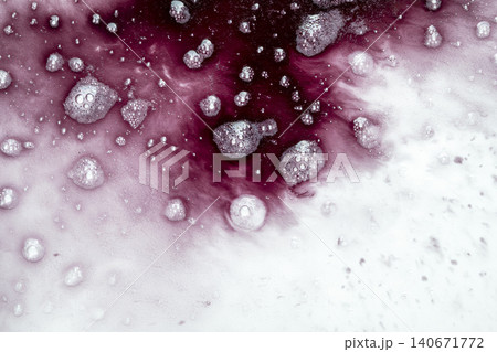 Abstract macro shot of dark red liquid, ink, or chemical reacting with a white textured, crystalline or powdery substance, creating bubble patterns and a soft gradient bleed 140671772