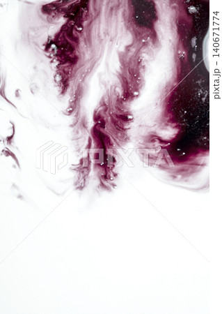 An abstract macro shot of deep red and maroon ink mixing and swirling in a white fluid, creating beautiful fluid patterns, bubbles, and textures with copy space at the bottom 140671774