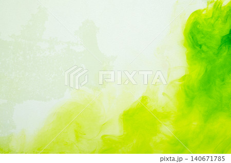 A vibrant abstract background featuring bright green and lime yellow ink or watercolor paint diffusing and swirling smoothly on a light textured canvas surface A vibrant abstract background featuring bright green and lime yellow ink or watercolor paint diffusing and swirling smoothly on a light textured canvas surface 140671785