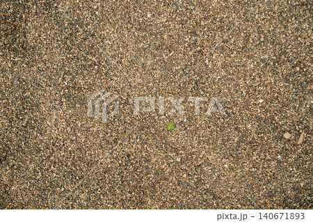 Brown quarry sand layer close-up with uneven mineral grain density, highlighting earthy tones and rough 140671893