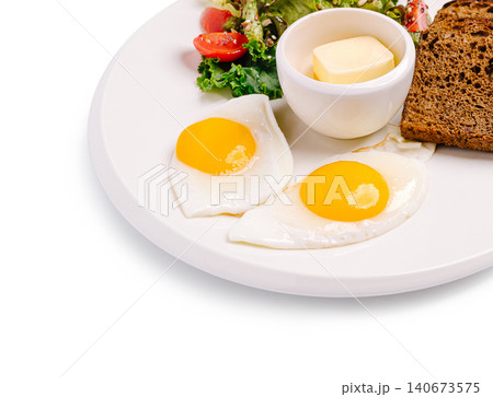 Fried eggs with fresh salad and toast on plate 140673575