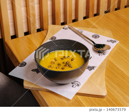 Pumpkin soup with seeds on wooden table 140673579