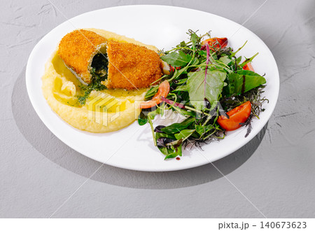 Chicken kiev with mashed potatoes and fresh green salad 140673623