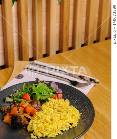 Beef stew with turmeric rice and fresh salad Beef stew with turmeric rice and fresh salad 140673899