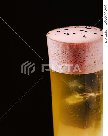 Refreshing yellow cocktail with pink foam and black sesame seeds 140674044