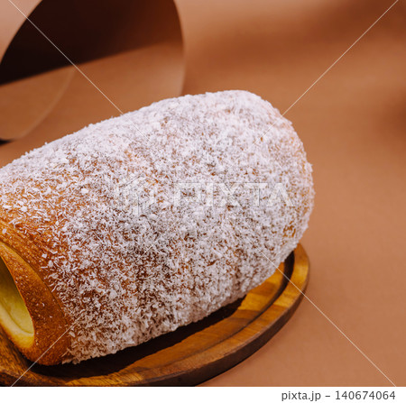 Kurtoskalacs chimney cake covered in shredded coconut on wooden plate Kurtoskalacs chimney cake covered in shredded coconut on wooden plate 140674064