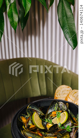 Steaming mussels in black pot with lime and toast Steaming mussels in black pot with lime and toast 140674114