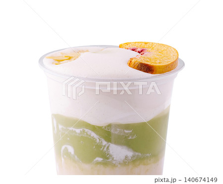 Matcha peach latte with foam and fruit slice Matcha peach latte with foam and fruit slice 140674149