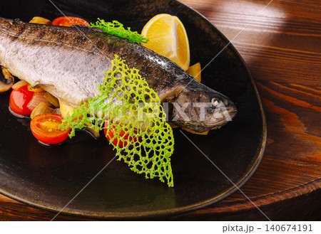 Grilled whole trout with lemon and cherry tomatoes 140674191