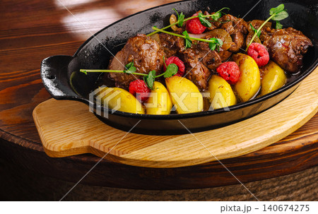Duck liver with roasted pears and raspberries in cast iron 140674275