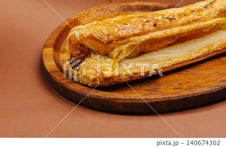 Sausage roll with puff pastry on wooden plate Sausage roll with puff pastry on wooden plate 140674302