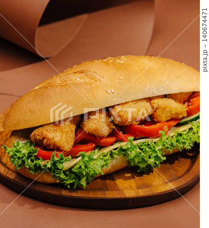Chicken nugget sandwich on wooden plate brown background Chicken nugget sandwich on wooden plate brown background 140674471