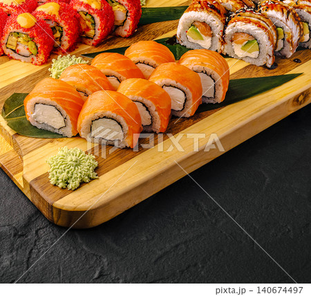 Assortment of fresh sushi rolls on wooden board Assortment of fresh sushi rolls on wooden board 140674497