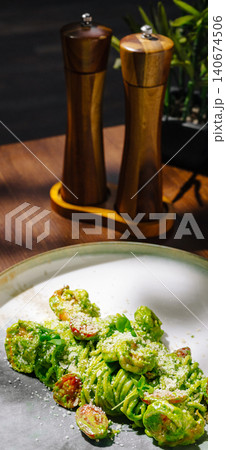 Green pesto pasta with shrimp, cherry tomatoes, and parmesan 140674506