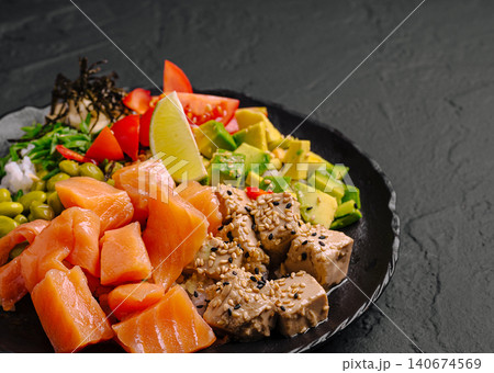 Healthy poke bowl with fresh salmon, avocado, tofu, and edamame Healthy poke bowl with fresh salmon, avocado, tofu, and edamame 140674569