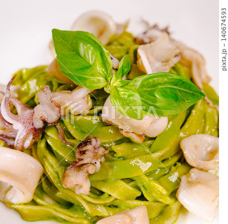 Green basil pesto pasta with fresh calamari seafood 140674593