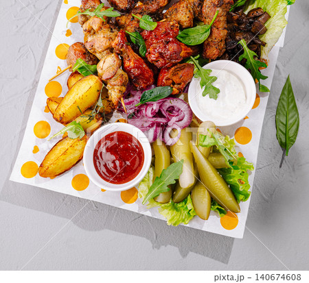 Grilled meat skewers platter with potatoes and pickles 140674608