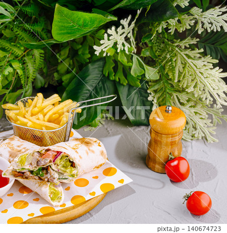 Chicken shawarma wrap with french fries and tomatoes Chicken shawarma wrap with french fries and tomatoes 140674723