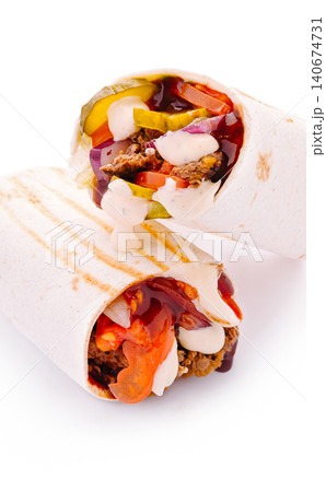 Beef shawarma wraps stacked with fresh vegetables and sauces Beef shawarma wraps stacked with fresh vegetables and sauces 140674731